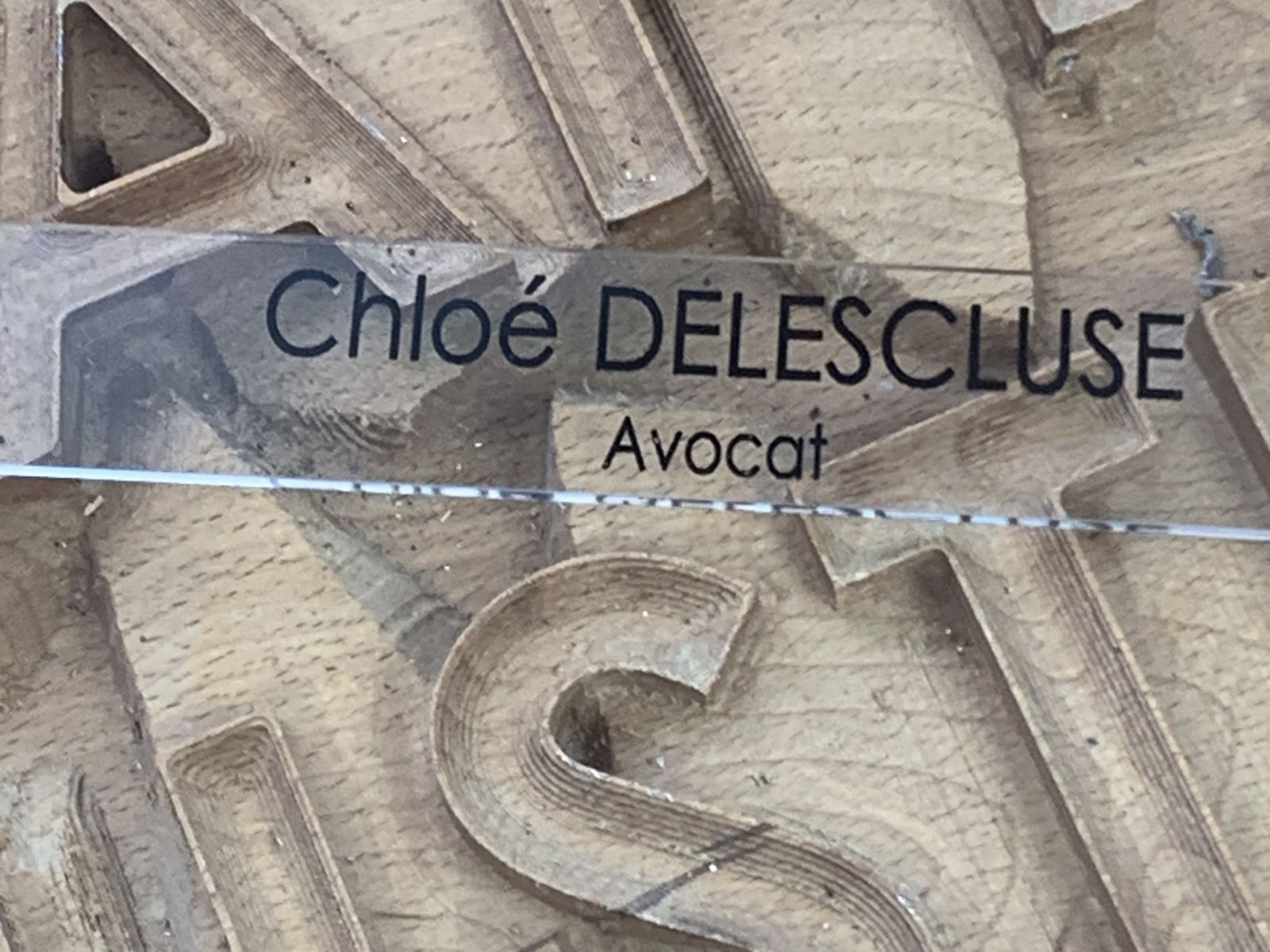 Plaquette professionnelle en plexiglas transparent avec gravure et peinture noire pour une avocate.